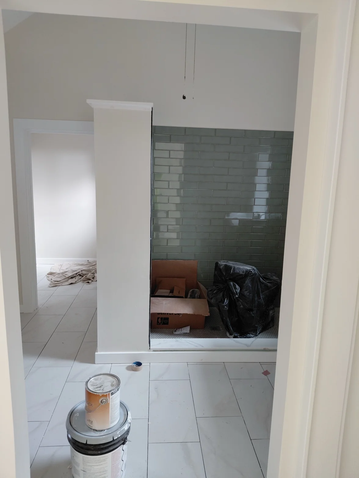 Bathroom mid-renovation with surfaces prepped and materials out before painting